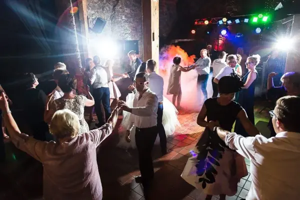 Hochzeitsgäste tanzen auf der Tanzfläche mit DJ-Licht und Nebelmaschine.